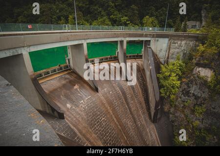 Kleiner, aber steiler Staudamm für das Wasserkraftwerk in Moste, Slowenien. Blick auf den hidroelektrischen Damm von oben, Blick nach unten. Stockfoto