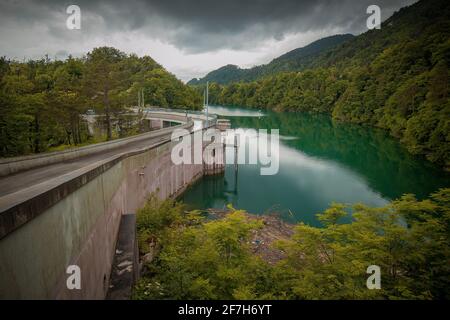 Kleiner, aber steiler Staudamm für das Wasserkraftwerk in Moste, Slowenien. Blick auf den hidroelektrischen Damm von oben, Blick nach unten. Stockfoto