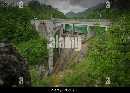 Kleiner, aber steiler Staudamm für das Wasserkraftwerk in Moste, Slowenien. Blick auf den hidroelektrischen Damm von oben, Blick nach unten. Stockfoto