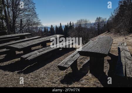 Holzbänke für Wanderer und Radfahrer auf dem Gipfel des Hügels mit einem schönen Blick ins Tal. Aussichtspunkt mit einer Bank. Stockfoto