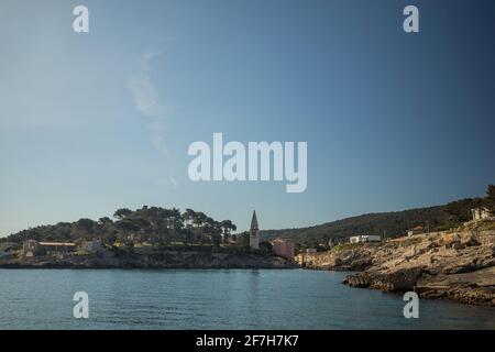 Blick auf das Dorf Veli Losinj auf der kroatischen Insel. Blick auf den Hafen oder den Hafen des Dorfes. Schöne bunte Häuser und Kirche sind Stockfoto