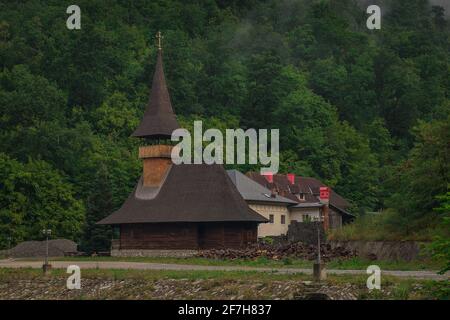 Blick auf das Wodita-Kloster in Rumänien an einem trüben, trüben Morgen, das Kloster versteckt sich in einem dichten grünen Wald. Stockfoto