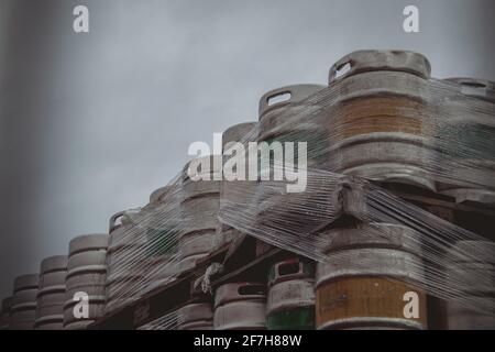 Große Mengen von Aluminium-Bierkegs, die mit Euro-Paletten übereinander gestapelt und mit Vinylfolie umwickelt wurden. Stockfoto