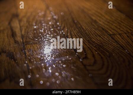 Schlechter oder rauer Lack auf Parkettboden. Schlechter Zustand des Holzbodens, wellige und unebene Lackoberfläche. Stockfoto