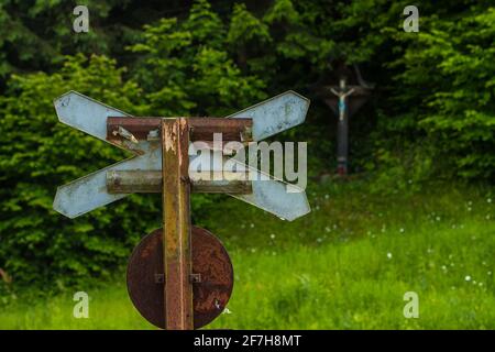 St. Andrews Kreuz in der Natur mit einem jesus auf einem Kruzifix im Hintergrund gesehen. Konzeptfoto einer gefährlichen oder tödlichen Bahnüberfahrt. Tod im Zug Stockfoto