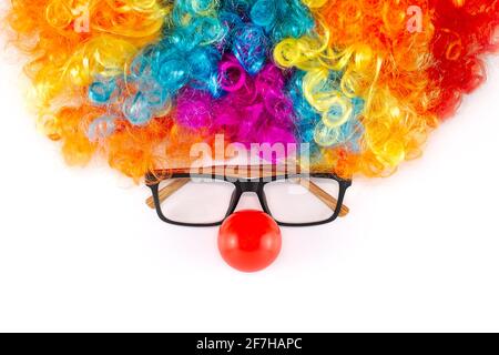 Lustige Party Konzept Gesicht gebildet. Regenbogen Clown Perücke Set mit Brille und rote Clown Nase wie ein Gesicht, flauschige Afro Synthetisch Cosplay Anime Fancy Perücken Stockfoto