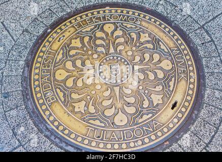 Typische dekorative, gemusterte runde Messing Schachtabdeckung in der Straße, Pest, Budapest, Hauptstadt von Ungarn, Mitteleuropa Stockfoto