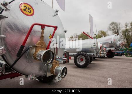 Szene aus einer Betriebsmesse, die eine Sammlung von Gülletanks in Edelstahlfarbe zeigt. Detail der Schlauchkupplungen an einem Tankwagen. Stockfoto