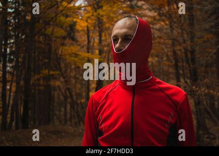 Person, die im Wald dumm aussieht, mit einem Buf oder einem Kopfband, das nur teilweise über den Kopf gezogen wird. Das Tragen eines Stirnbands im Kenny-Stil. Stockfoto