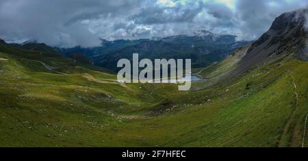 Panorama vom Großglockner Passan einem Sommertag mit schönen Wolken, grünen Wiesen und kurvenreichen Straße unten gesehen. Sommer auf Bergpass. Stockfoto