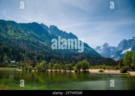 See Jasna in Kranjska gora, slowenien, mit Bergen im Hintergrund. Schönes spätes Frühlingspanorama der julischen alpen über dem See Jasna. Stockfoto