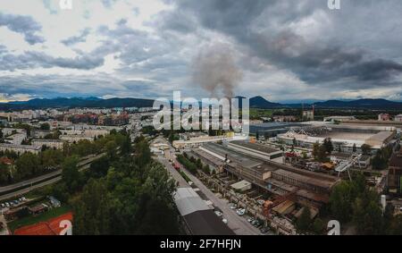 Luftaufnahme eines Brandes im Industriegebiet Stegne in Ljubljana, Slowenien. Dunkle Rauchwolke steigt vom Zündort aus sichtbar auf. Gefahr Stockfoto