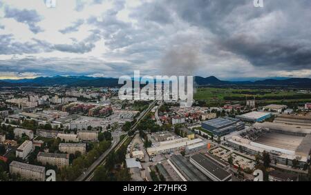 Luftaufnahme eines Brandes im Industriegebiet Stegne in Ljubljana, Slowenien. Dunkle Rauchwolke steigt vom Zündort aus sichtbar auf. Gefahr Stockfoto