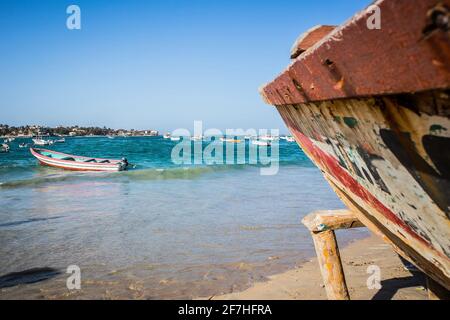 Typische Fischerboote in Yoff Dakar, Senegal, genannt Pirogue oder Piragua oder Piraga. Farbenfrohe Boote, die von Fischern benutzt werden, stehen am Ufer und schauen nach Stockfoto