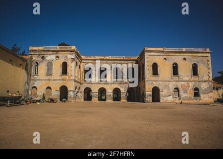 Stadthaus in einem schlechten Zustand auf der berühmten Sklaveninsel Goree. Kolonialgebäude auf einer touristischen Insel goree an einem sonnigen Tag mit blauem Himmel. Stockfoto