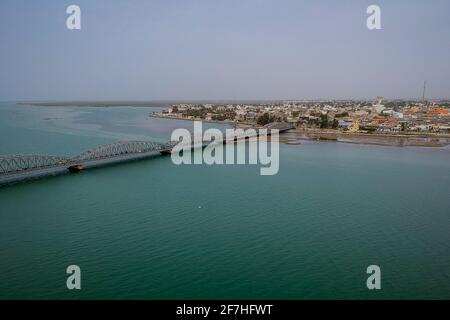 Luftaufnahme des Senegal-Flusses in Sant Louis, Senegal, mit der Faidherbe-Brücke, die den neuen Teil der Stadt an einem bewölkten Tag verbindet. Stockfoto