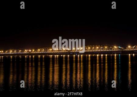 Faidherbe-Brücke, eine Metallbrücke, die in der späten Nacht in Sant Louis, Senegal, mit einem Auto und einigen Leuten über den Fluss springt. Stockfoto