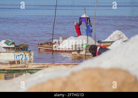 LAC ROSE, SENEGAL, FEBRUAR 17 2017: Menschen ernten Salz auf Lac Rose oder Lake Retba, in der Nähe von Dakar im Senegal. Ein Boot mit Salz und einem zwei afrikaner Stockfoto