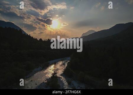 Schöner Sommerabend mit Sonne gerade untergehen behnd julischen alpen und Fluss in Resia Region oder Rezija, in der Nähe von Resciutta Dorf. Dörfer in der Nähe Stockfoto