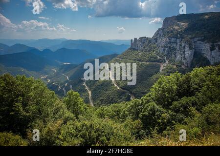 Blick vom Col de Rousset in Frankreich. Kurvenreiche Straße mit zwei Kurven und scharfen Kurven, die an einem bewölkten Tag mit einigen Bäumen im BA vom Aussichtspunkt aus gesehen werden Stockfoto