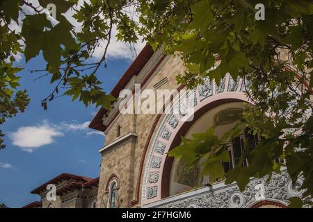 Außenfassade eines Bahnhofs in Chisinau, Moldawien, versteckt hinter den Bäumen an einem schönen sonnigen Tag. Detail des Hauptgebäudes. Stockfoto