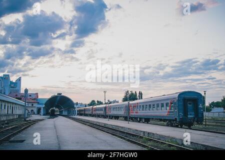 Fahrgastseite des Bahnhofs in Chisinau, Moldawien an einem Sommerabend. Zwei Züge warten auf den Bahnsteigen, um Passagiere und Touristen zu erhalten. Stockfoto