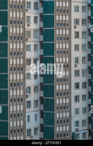 Typische sozialistische oder sowjetische Wohnblöcke in einer Stadt, verfallende Fassade in grün-weißer Farbe, Fliesen fehlen von Zeit zu Zeit. Alte Appartements Stockfoto