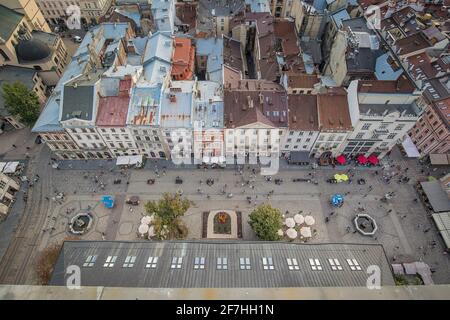 Vogelansicht von der Spitze des Rathausturms in Lviv, Ukraine, mit Blick auf den Stadtplatz und die Häuser in der Umgebung. Sichtbare Menschen und zwei schöne fo Stockfoto