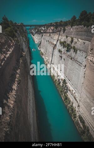 Korinth oder korinthischer Kanal in Griechenland. Eine schmale Wasserstraße, die das Ionische Meer mit dem Ägäischen Meer verbindet. Enger Wasserdurchgang in Fels gehauen an einem sonnigen Tag. Stockfoto