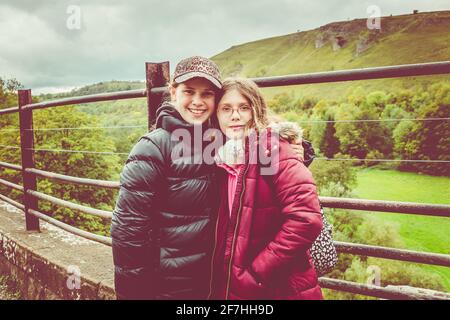 Zwei Teenager/zwei Mädchen auf einer Wanderung, die an einem kalten Tag auf dem Grabstein-Viadukt in Monsal Dale, dem Peak District, Derbyshire, wandern Stockfoto