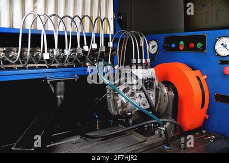 Die Kraftstoffpumpe für den Dieselmotor nach der Reparatur auf dem Einstellstand in der Werkstatt, die Reparatur der Kraftstoffpumpe, die Einstellung der Zapfpistolen auf der Bank, der Kraftstoff Stockfoto