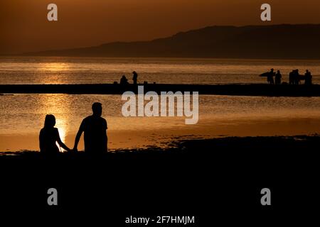 Tarifa, Cádiz, Spanien - 23. Juni 2017: Silhouetten von Menschen bei einem atemberaubenden Sonnenuntergang am Strand von Tarifa, Spanien. Stockfoto