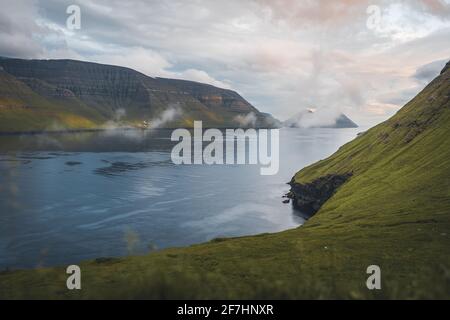 Färöer-Inseln Kalsoy im Sonnenuntergang Licht durig Dämmerung mit rosa Himmel und Klippen. Stockfoto