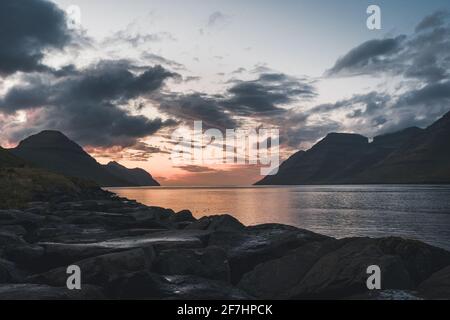 Färöer-Inseln Kalsoy im Sonnenuntergang Licht durig Dämmerung mit rosa Himmel und Klippen. Stockfoto