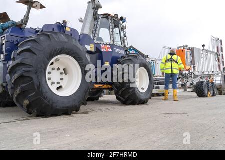 Ein Volunteer überprüft den Strandtraktor TW56H vor dem RNLI Rye Harbor Lifeboat Station Stockfoto