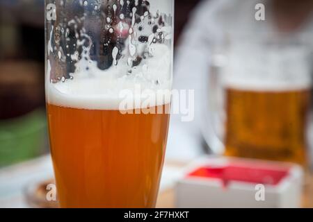 Nahaufnahme und selektive Unschärfe auf einem Bierkrug mit einem Weizenbier im Stil von Weissenbier, serviert in einem Standard-Glas in Pint-Größe Bild eines Bierkrug mit Stockfoto