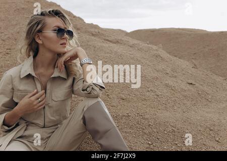 Eine attraktive Frau sitzt zwischen den Sanddünen. Stockfoto
