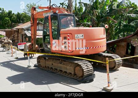 Das rote alte Hitachi Baggerlader steht auf einer neu gezementierten Straße auf Boracay Island, Provinz Aklan, Philippinen Stockfoto