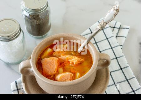 Hausgemachte Suppe mit Lachs mit Brotscheiben auf Marmorboden Stockfoto