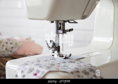 Junge Frau näht Kleidung auf der Nähmaschine. Nahaufnahme Stockfoto