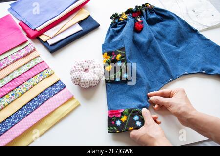 Die letzten Feinheiten werden an der Hose gemacht, die für Baby Boy genäht wurde. Selective Focus Hose Stockfoto