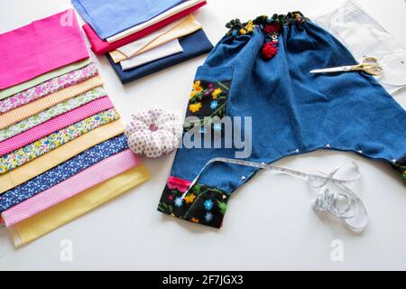 Die letzten Feinheiten werden an der Hose gemacht, die für Baby Boy genäht wurde. Selective Focus Hose Stockfoto