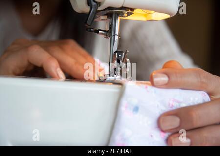 Junge Frau näht Kleidung auf der Nähmaschine. Nahaufnahme Stockfoto