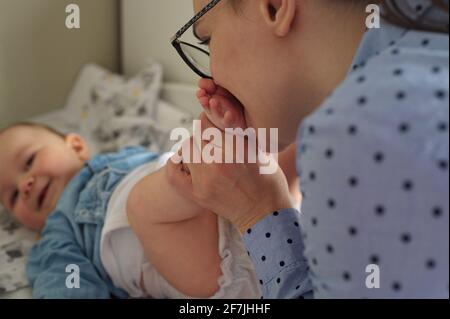 Mutter, die Windeln von niedlichen kleinen Jungen wechselt Stockfoto