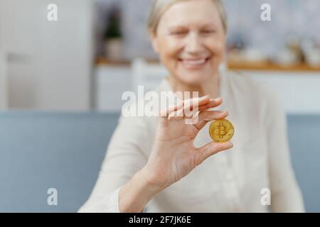 Attraktive Dame, die Bitcoin in ihren Händen ansieht. Stockfoto