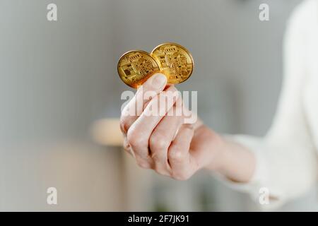 Nahaufnahme. Zwei Bitcoins in den Händen einer Geschäftsfrau. Stockfoto