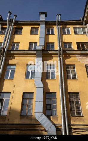 Lüftungsrohre an der Fassade des alten gelben Hauses Stockfoto