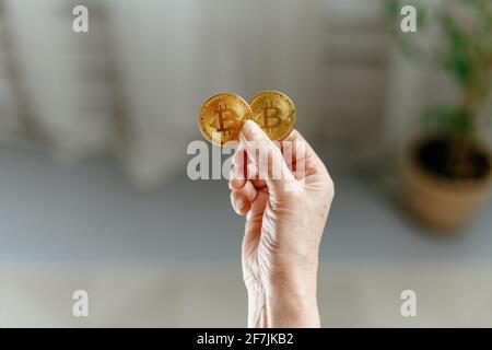 Bild von zwei Bitcoins in den Händen einer Frau. Stockfoto
