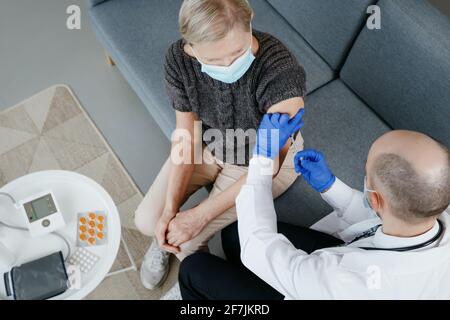 Arzt, der einer reifen Frau eine Injektion verabreicht. Stockfoto