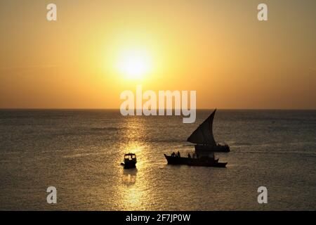 Fischerboote im Sonnenuntergang von der Terrasse des Afrikanischen Hauses in Stonetown, Sansibar in Tansania, Afrika. Stockfoto